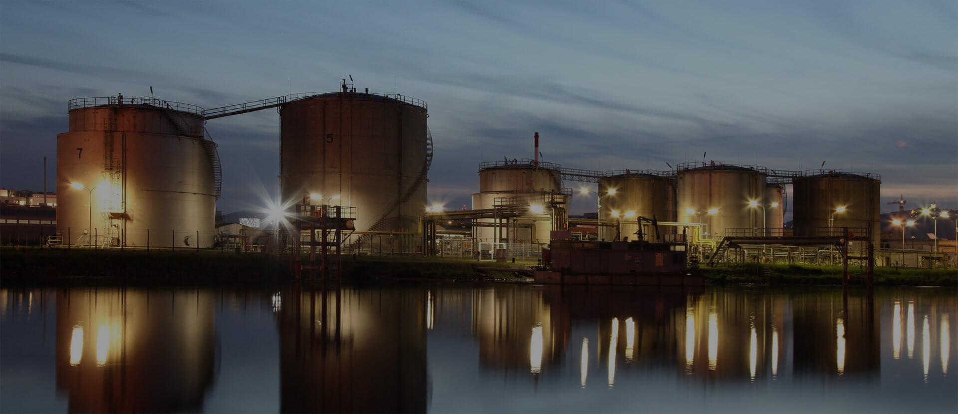 Worker managing industrial tanks and calculating flare emissions for compliance.