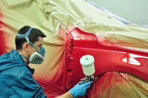 Spray-Booth-worker-using-an-aerosol-paint-applicator.