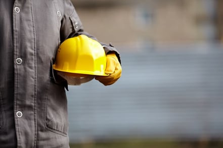 worker holding yellow helmet